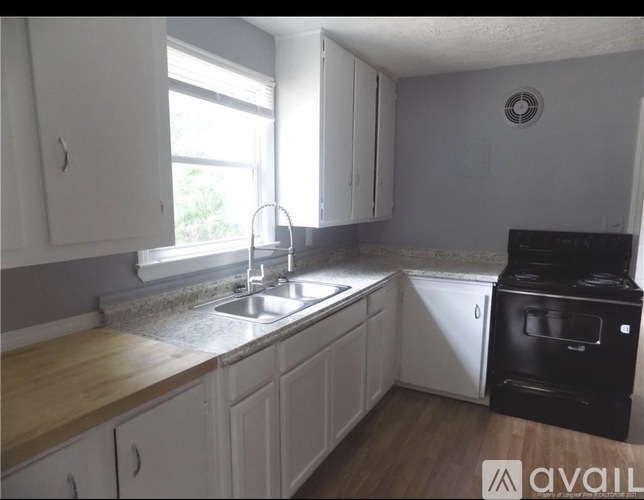A kitchen with white cabinets and a black oven.