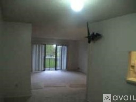 A room with a ceiling fan and a window with curtains.