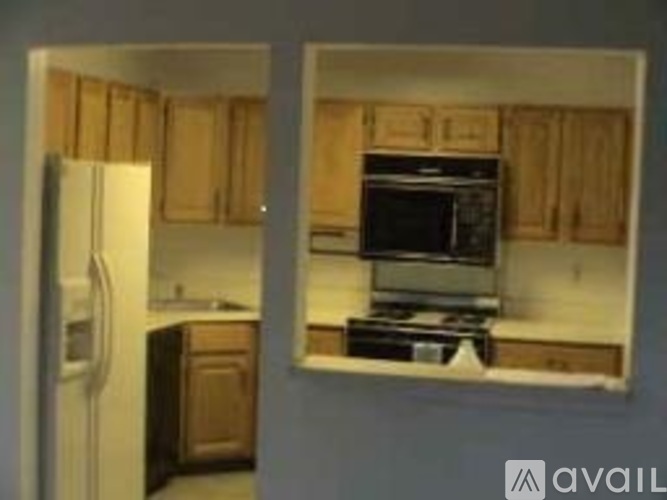 A kitchen with wooden cabinets and a black stove top oven.
