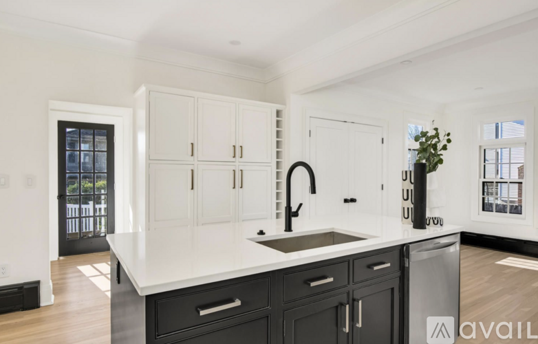 A kitchen with black and white cabinets and a sink.