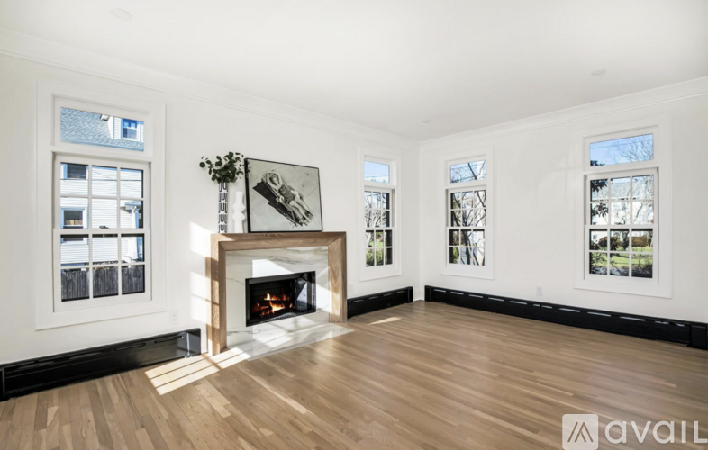 A living room with a fireplace and a framed picture on the wall.