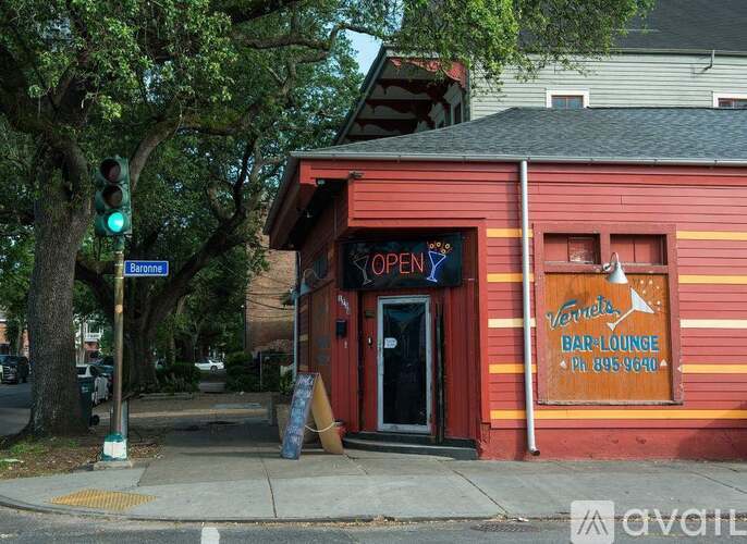 A red building with a sign that says "Verna's Bar Lounge" is open.