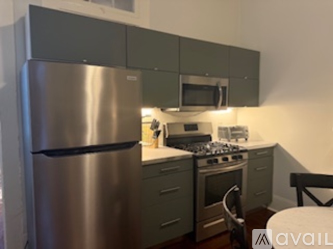 A kitchen with a stainless steel refrigerator and a stove.
