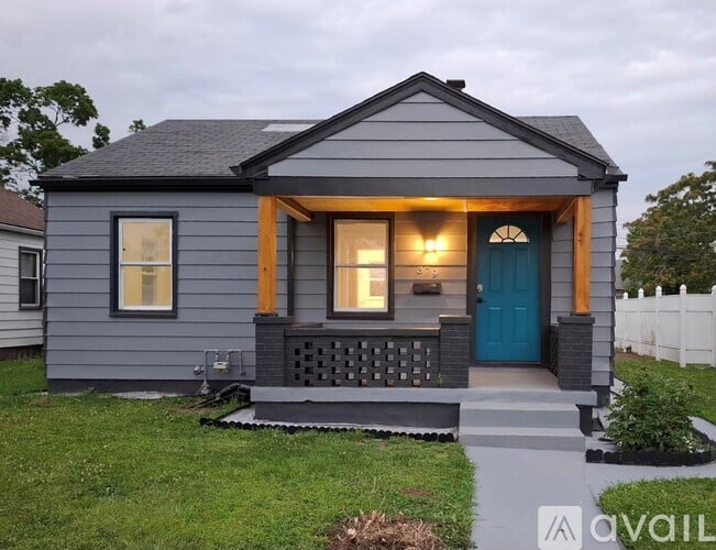 A small house with a blue door and windows is for sale.