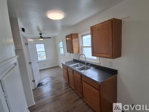 A kitchen with wooden cabinets and a black countertop.