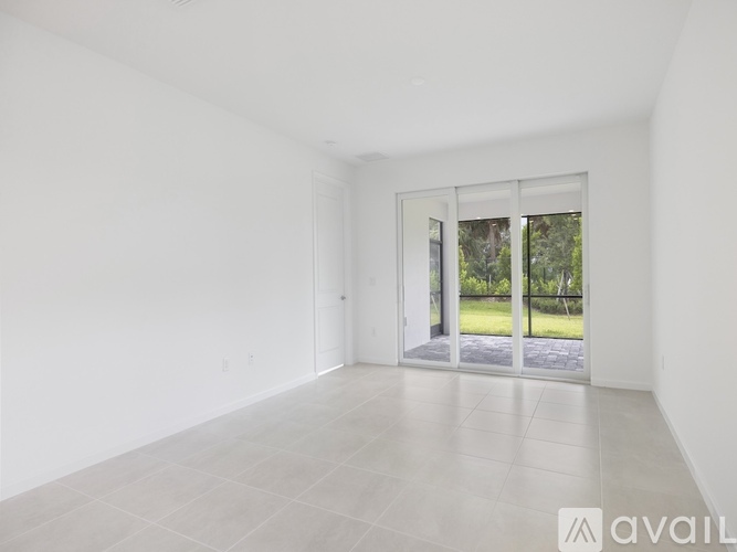 A spacious room with a sliding glass door leading to a patio.