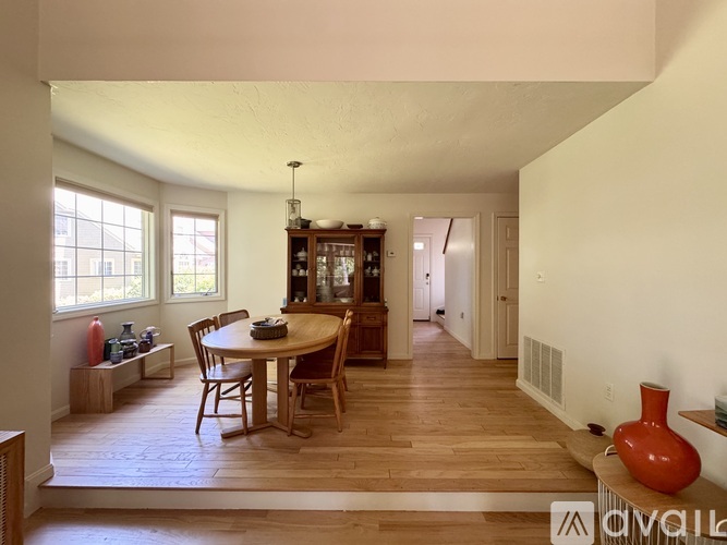 A dining room with a wooden table and chairs.