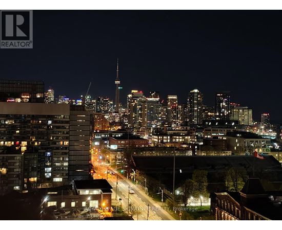 A cityscape at night with the CN Tower visible in the distance.