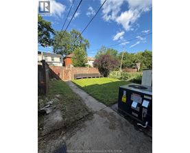 A backyard with a fence and a utility box.