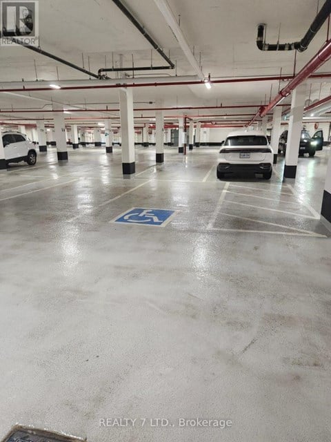 A parking garage with a white car and a black car parked in it.