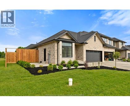 A modern house with a well-maintained lawn in front.