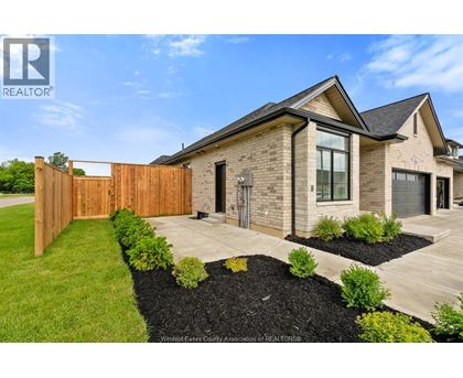 A modern house with a wooden fence and a well-maintained garden.