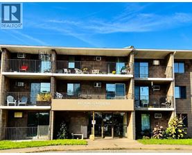 A multi-story apartment building named Lauzon Gardens is shown with balconies and outdoor furniture.