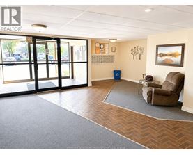 A realtor's office with a brown chair and a calendar on the wall.