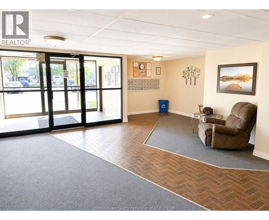 A realtor's office with a brown chair and a calendar on the wall.
