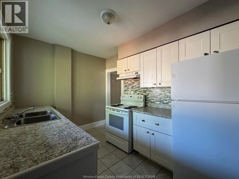A kitchen with a sink, stove, and oven.
