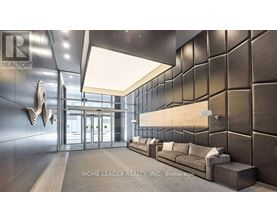 A lobby with a dark wall and a light ceiling.