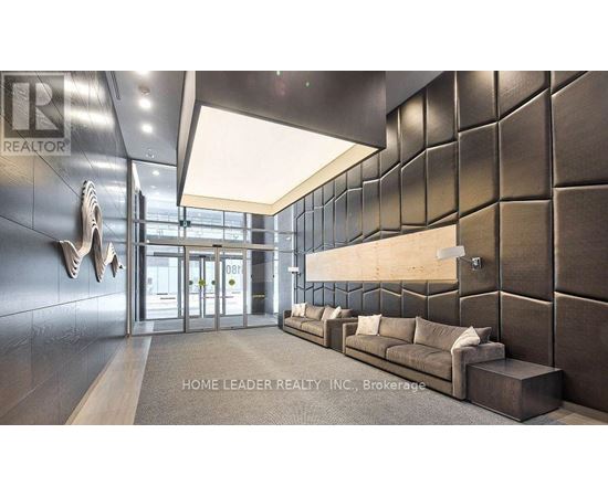A lobby with a dark wall and a light ceiling.