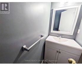 A bathroom with a sink, mirror, and towel rack.