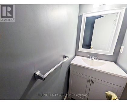 A bathroom with a sink, mirror, and towel rack.