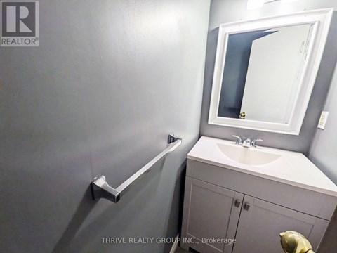 A bathroom with a sink, mirror, and towel rack.