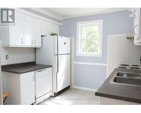 A kitchen with white appliances and cabinets.