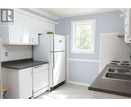 A kitchen with white appliances and cabinets.