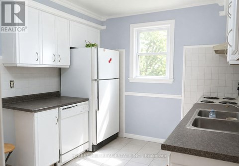 A kitchen with white appliances and cabinets.