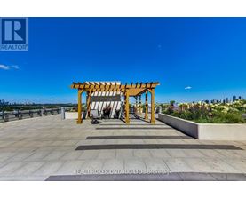 A wooden pergola is situated on a rooftop terrace.