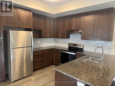 A kitchen with a granite counter top and stainless steel appliances.