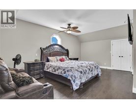 A bedroom with a large bed and a ceiling fan.