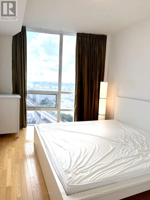A bedroom with a large bed and a view of the city.