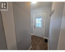 A white door with a glass window is in a room with wooden flooring.