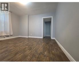 A room with wooden flooring and a doorway leading to another room.