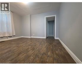 A room with wooden flooring and a doorway leading to another room.