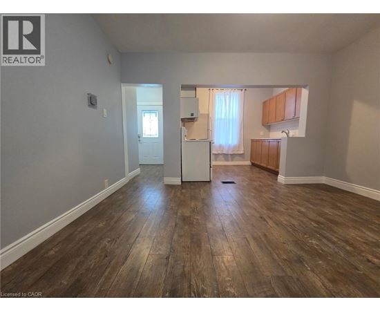 A room with wooden flooring and a white door.