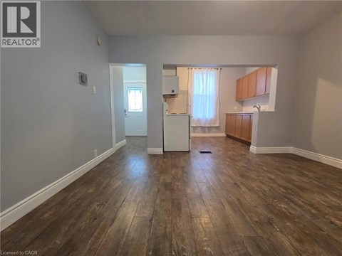 A room with wooden flooring and a white door.