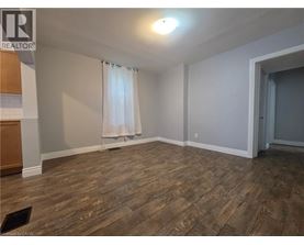 A room with wooden flooring and a window with curtains.