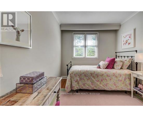A bedroom with a bed, nightstand, and a window with blinds.
