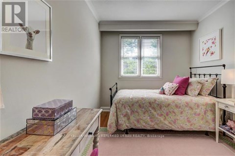 A bedroom with a bed, nightstand, and a window with blinds.