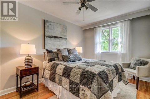 A bedroom with a bed, a ceiling fan, and a window.