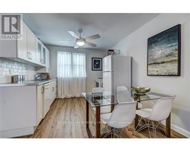 A kitchen with a glass table and white chairs.