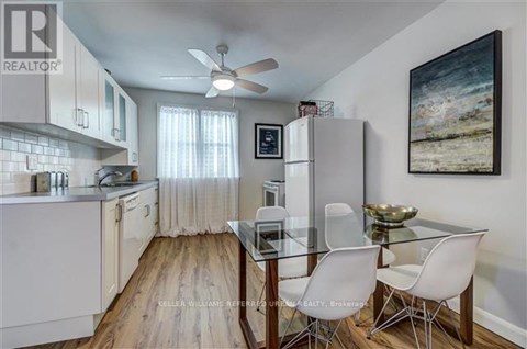 A kitchen with a glass table and white chairs.