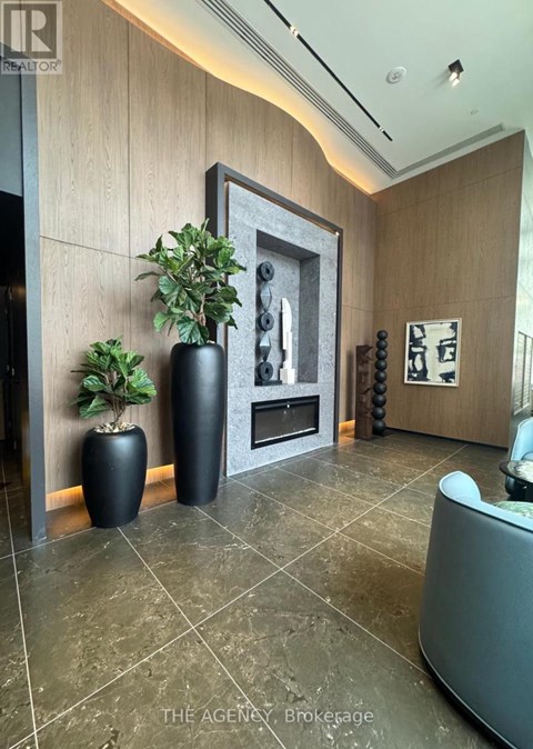 A living room with a grey couch and a framed picture on the wall.