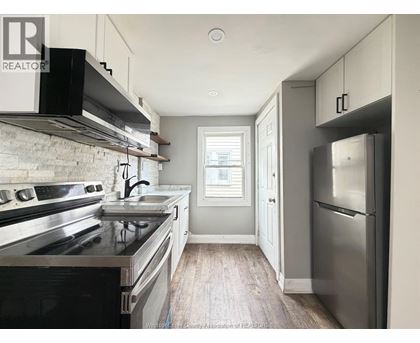 A kitchen with a stove top oven and a refrigerator.