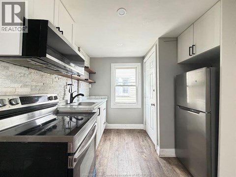 A kitchen with a stove top oven and a refrigerator.