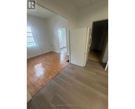 A room with wooden flooring and a white door.