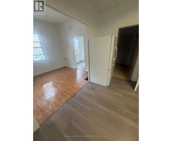 A room with wooden flooring and a white door.