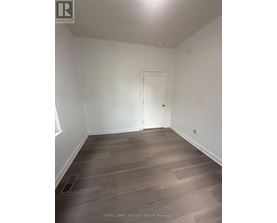 A room with wooden flooring and a white door.