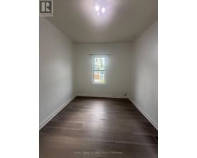 A room with wooden flooring and a window.
